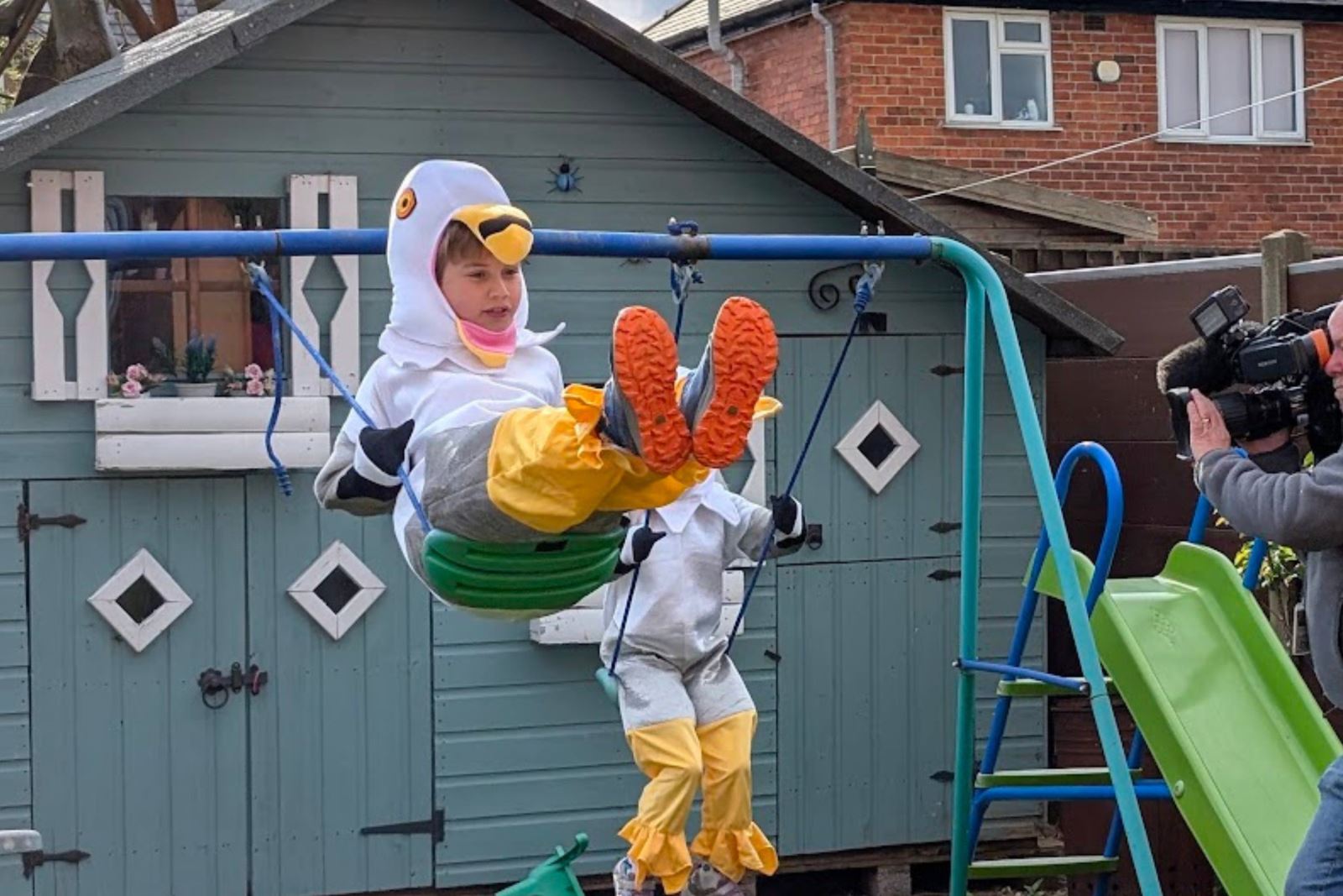 Seagull Boy Cooper Wallace in his seagull costume on a garden swing